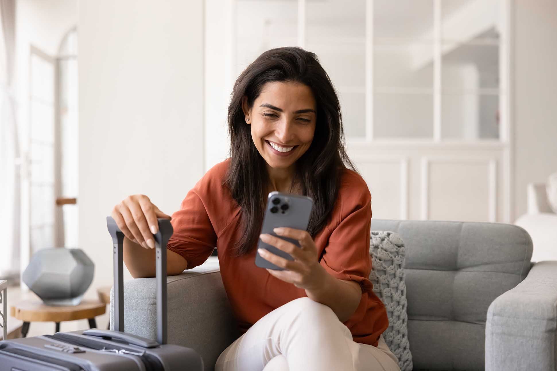 Cheerful tourist lady booking on smartphone